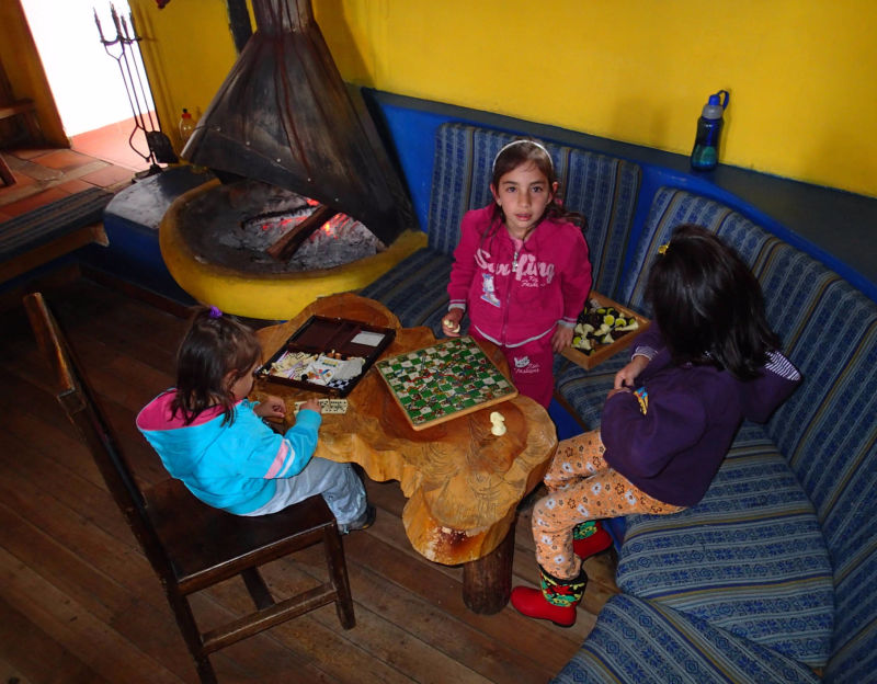 Children play ladder game at the fireplace in Cuello de Luna